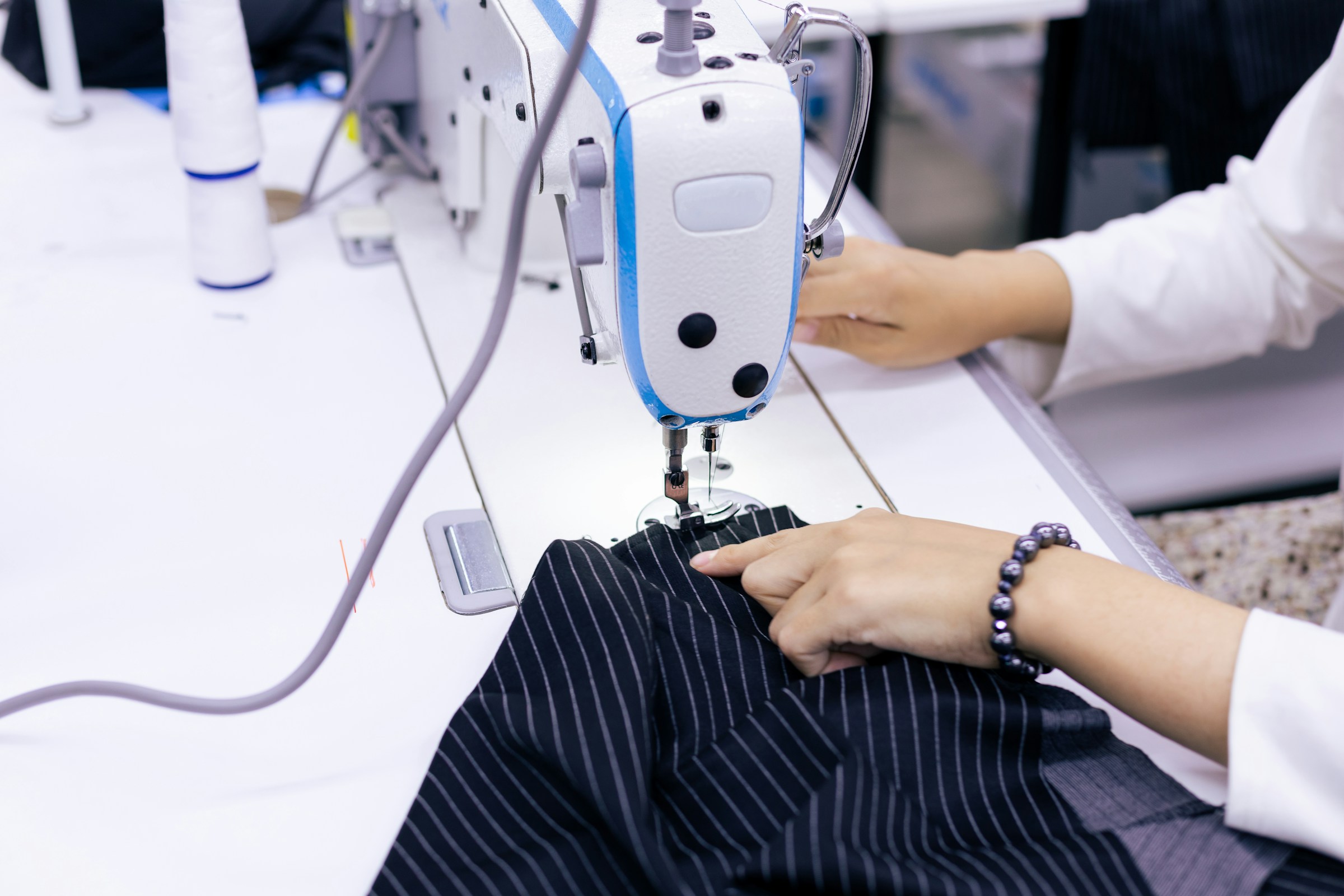 Industrial lockstitch machine joining pinstripe suiting fabric on an audited EETHEN partner factory line