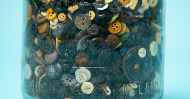 Garment buttons and trims collected in a glass jar